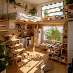 a loft bed with stairs leading up to the top floor and an open kitchen area