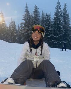 a woman sitting in the snow with her skis on