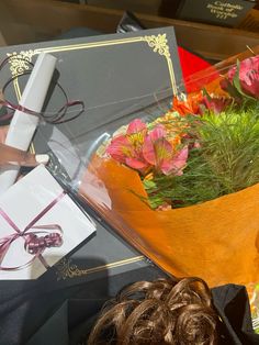 a bouquet of flowers in a vase on top of a table next to an open book