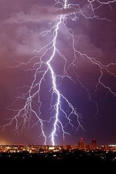 lightning strikes over the city at night time