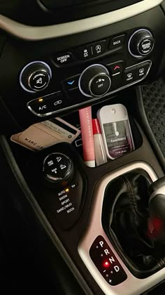 the interior of a car with various items in it's center console and control buttons