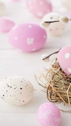 some pink and white eggs sitting in a nest