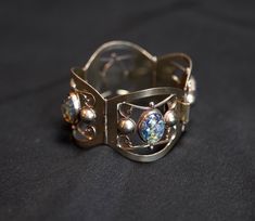 "This silver and art glass Mexican bracelet is in very nice vintage condition. The clasp works beautifully. All of the art glass pieces are accounted for. Signed on back. Width - 1 1/2\" at widest point Length - 6 1/4\" Find more vintage bracelets from my shop here! ~ https://www.etsy.com/shop/AnnWoodallStudios?ref=seller-platform-mcnav&section_id=22220877 If you are interested in a vintage item, please examine the photographs carefully and feel free to contact me with any questions you might have. I'll do my best to answer them, though I am not a professional jewelry dealer or appraiser.  For questions regarding the cost of repairing and/or cleaning any of the jewelry or purses, I would suggest contacting your local jeweler for his or her opinion. I am listing the jewelry and purses as I Silver Artistic Bracelets For Formal Occasions, Artistic Silver Bracelets For Formal Occasions, Artistic Formal Bracelet Jewelry, Hallmarked Antique Silver Cuff Bangle Bracelet, Iridescent Vintage Jewelry For Collectors, Vintage Sterling Silver Cuff Bracelet With Patina, Collectible Vintage Iridescent Jewelry, Vintage Sterling Silver Nickel-free Cuff Bracelet, Vintage Silver Hand-tooled Cuff Bracelet