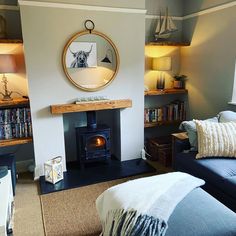 a living room filled with furniture and a fire place in front of a mirror on the wall