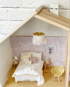 a doll house with a bed, chair and table