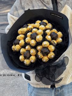 a person holding a bouquet of chocolates in their hands