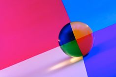 a colorful ball sitting on top of a white and blue floor next to a pink wall