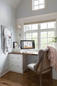 a desk with a computer on top of it next to a window in a room