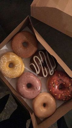 a box filled with assorted donuts on top of a table