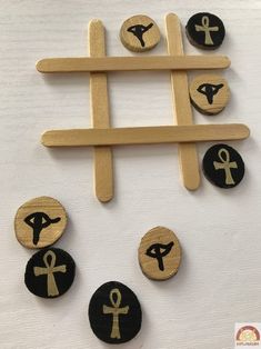 wooden pegs with black and white images on them, depicting different symbols in the form of an x