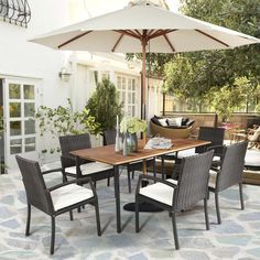 an outdoor dining table and chairs with an umbrella