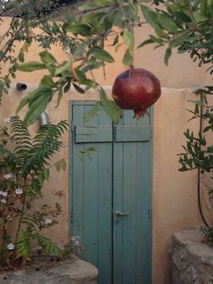 an apple hanging from the top of a door in front of a building with trees