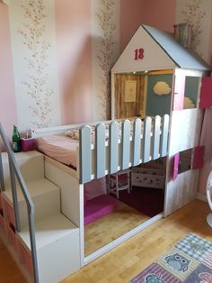 a child's bedroom with a doll house bed and stairs