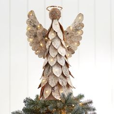 a christmas tree with an angel decoration on it's top and lights hanging from the branches