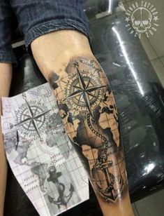 a man's arm with a compass and an anchor tattoo on the left forearm