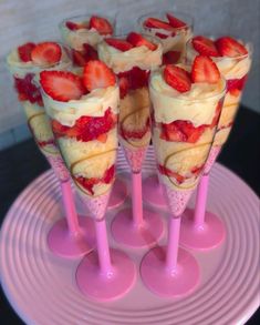 strawberries are arranged in cones on a pink plate