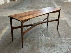 a wooden table sitting on top of a cement floor