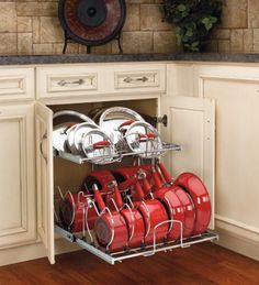 an open dish rack with many pots and pans on it in a white kitchen