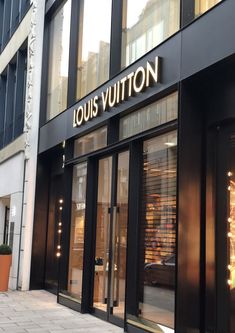 louis vuitton store front with large windows and gold lettering on the outside wall