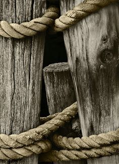 black and white photograph of rope wrapped around wooden posts