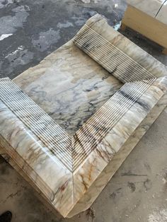 a marble table top sitting on top of a cement floor next to a pile of boxes