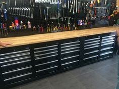 a man standing in front of a counter filled with lots of tools