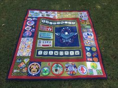 a patchwork quilt on the ground covered in various patches and stickers, all depicting different types of buttons