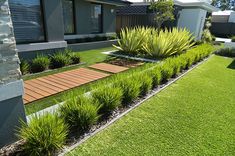 an outdoor garden with grass and wooden walkways