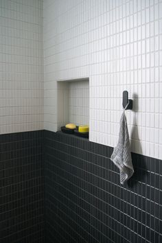 a black and white tiled bathroom with two yellow bowls on the shelf next to it