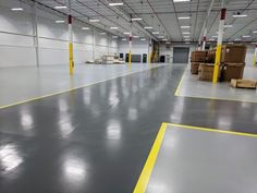 an empty warehouse with boxes on the floor and yellow lines painted on the floor in front of it