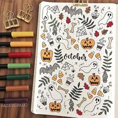 an open halloween coloring book next to markers and crayons