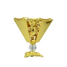 a gold colored vase sitting on top of a metal stand with an ornate design in the center