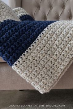 a crocheted pillow sitting on top of a couch next to a white chair