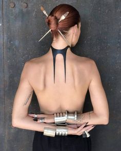 the back of a woman's body with nails on her head and fingers in her hands