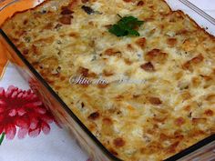 a casserole dish with meat and cheese in it sitting on a tablecloth