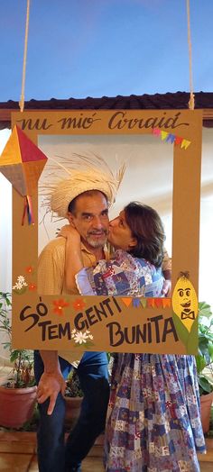 a man and woman are kissing in front of a sign that says go tempenti bunita