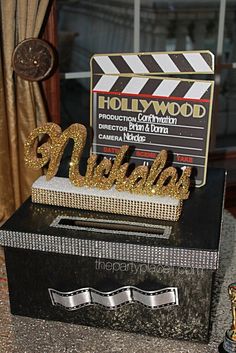 there is a sign that says hollywood in front of a movie clapper and award