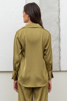 Our Olive Satin Long Sleeve Blouse is a must-have for every wardrobe. The rich, luxurious satin fabric adds a touch of elegance to any outfit, while the classic olive color is timeless and versatile. Perfect for any occasion, this blouse will quickly become your go-to choice for effortless style and sophistication. Olive Satin Long Sleeve Blouse Color - Light Olive Green Polyester Made in Vietnam Chic Olive Long Sleeve Tops, Luxury Olive Long Sleeve Tops, Olive Long Sleeve Cotton Shirt, Satin Long Sleeve Shirt With Button Closure, Olive Cotton Button-up Shirt, Satin Button Up, Buckle Bags, Satin Long Sleeve, Stylish Top