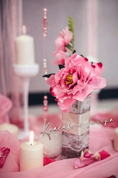 pink flowers and candles are on the table