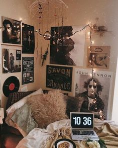 a bedroom with posters on the wall and a laptop computer sitting on top of it