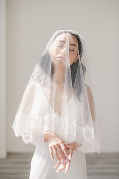 a woman wearing a veil and holding her hands together