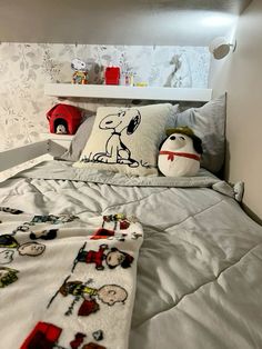 there is a bed with snoopy decorations on it and a pillow in the corner