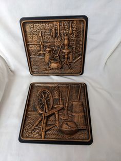 two decorative metal trays sitting on top of a bed