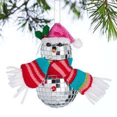 a snowman ornament hanging from a christmas tree with a disco ball on it