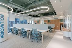 an office with white tables and chairs in front of a large sign that says innovation