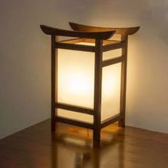 a lamp that is sitting on top of a wooden table next to a white wall