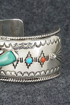 This stunning and substantial turquoise, coral and sterling silver bracelet was made by Navajo silversmith Emerson Delgarito. The inside is signed E. Delgarito and stamped sterling.Size: 5 3/8" (will fit up to a 6 1/2" wrist)Gap: 1 1/8"Length: 1 1/8"Free shipping on all orders! We ship with USPS and always include tracking. All orders ship within a day of payment.Returns are accepted up to 30 days after you receive your order. Just send us a message. Our shop offers cash back or store credit. Th Southwestern Silver Bracelet With Multi-stone, Southwestern Silver Multi-stone Bracelet, Artisan Silver Multi-stone Cuff Bracelet, Southwestern Silver Multi-stone Bracelets, Silver Artisan Multi-stone Cuff Bracelet, Southwestern Sterling Silver Inlay Bracelet Gift, Coral Turquoise, Sterling Silver Bracelet, Native American Jewelry