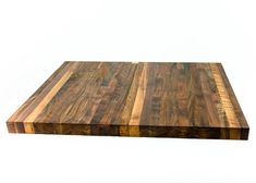 a large wooden cutting board sitting on top of a white surface with no one around it