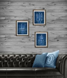 three framed photographs hang on the wall above a leather couch with blue pillows and throw pillows