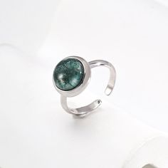 This delicate ring features stunning aquatic agate gemstones. The setting is meticulously crafted and the intricate details enhance the natural beauty of the stone, allowing its delicate hues to sparkle in the light. The adjustable strap ensures a comfortable fit, making it a versatile and elegant addition to any jewelry collection. Metal: 18K Recycled Gold Plated Vermeil on Recycled Sterling Silver,Recycled Sterling Silver Gemstone: Onyx 10mm Adjustable Ring Size: US 8 Adjustable Open Emerald Ring For Promise, Adjustable Emerald Ring, Adjustable Silver Turquoise Ring With Gemstone, Adjustable Opal Ring With Natural Stones, Adjustable Emerald Open Ring, Adjustable Elegant Opal Ring With Polished Finish, Adjustable Gemstone Crystal Ring For Formal Occasions, Adjustable Open Emerald Ring, Elegant Adjustable Crystal Ring With Stone Setting